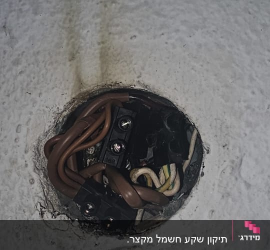 חוטי חשמל מחוברים לקופסת חיבורים בקיר